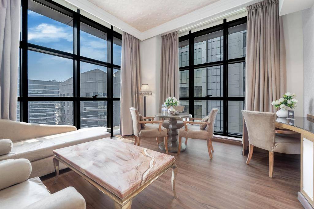 Suite living area with city views at The Leela Hotel Dubai